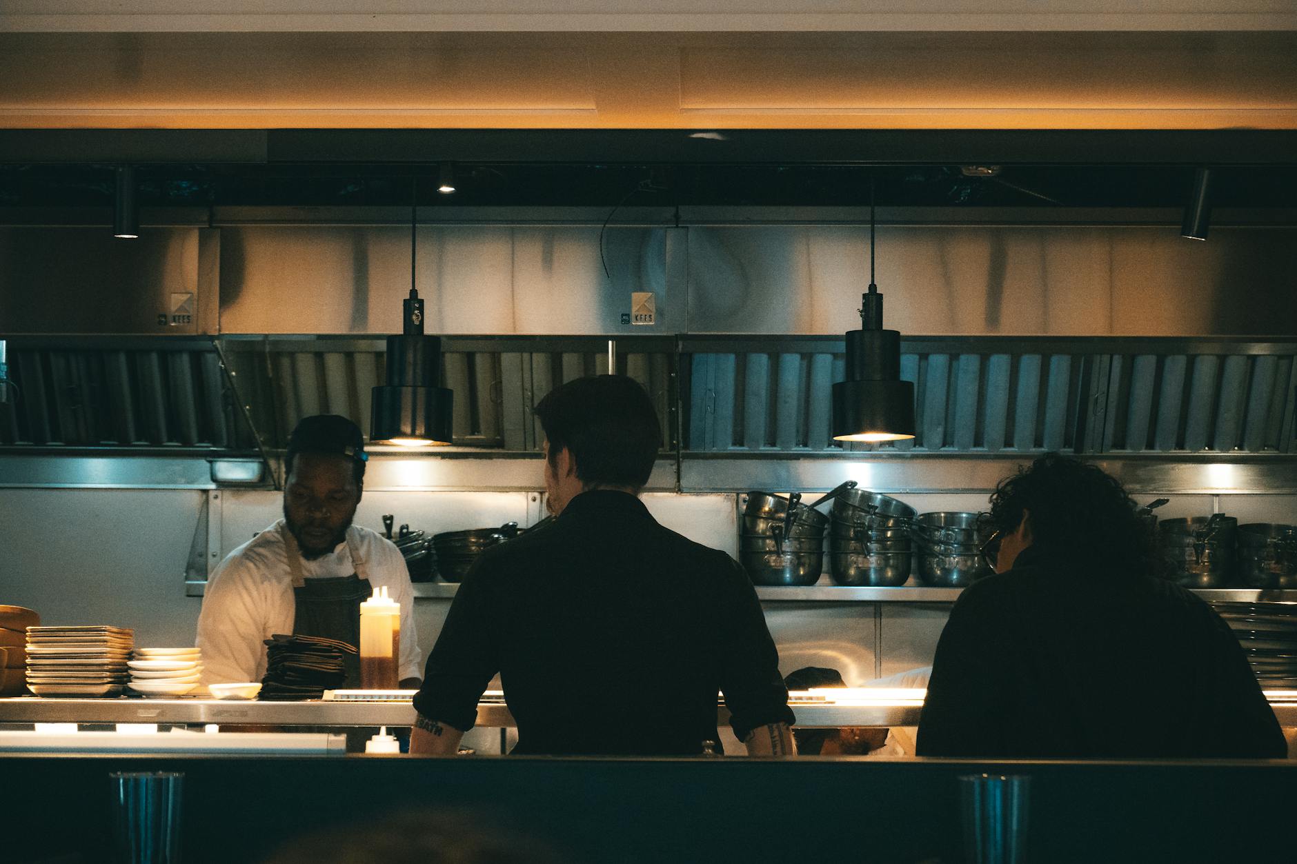 Chefs working in a bustling New York kitchen, evening scene.